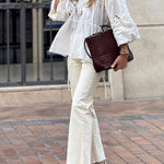 White blouse with a V-neckline and openwork sleeves